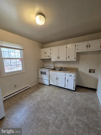 a view of a kitchen with cabinets and a stove top oven
