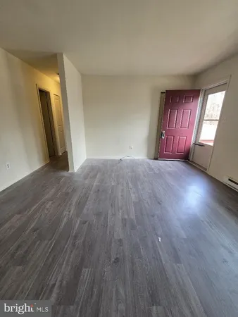 a view of an empty room and wooden floor with windows