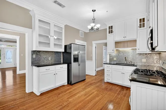 a kitchen with stainless steel appliances a stove refrigerator and cabinets