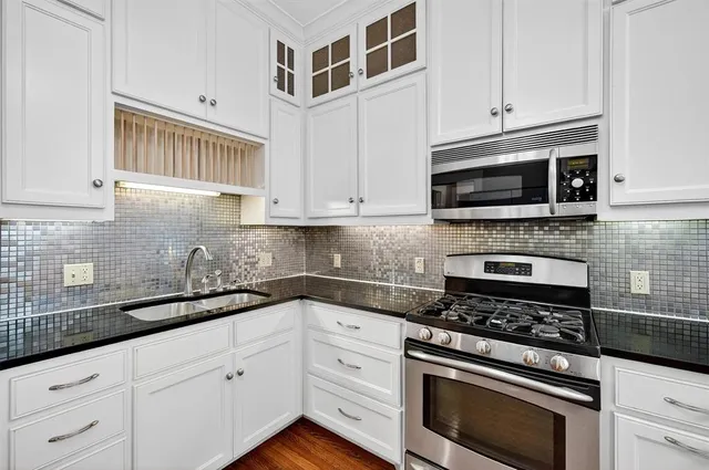 a kitchen with white cabinets and appliances