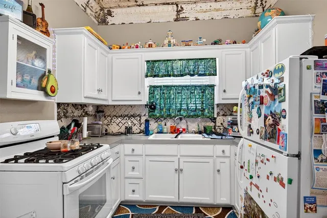 a kitchen with cabinets appliances a sink and a window