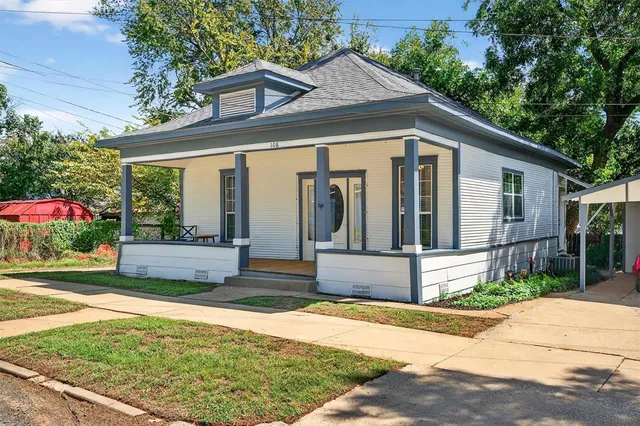 a view of a house with backyard and sitting area
