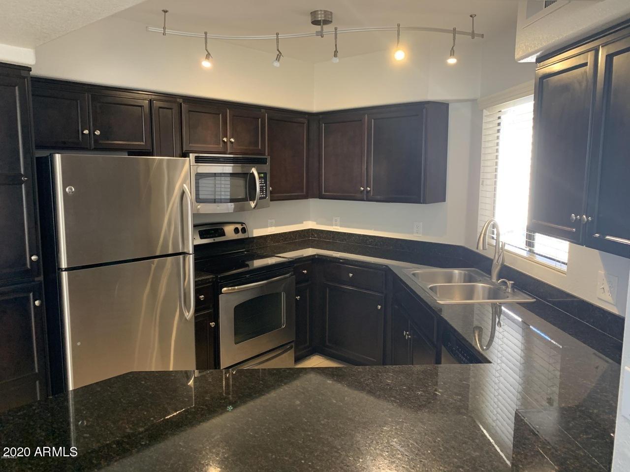 3848 North 3rd Avenue, Unit 3020 Phoenix, AZ 85013 - Photo 3 of 20 a kitchen with granite countertop stainless steel appliances a refrigerator and a sink