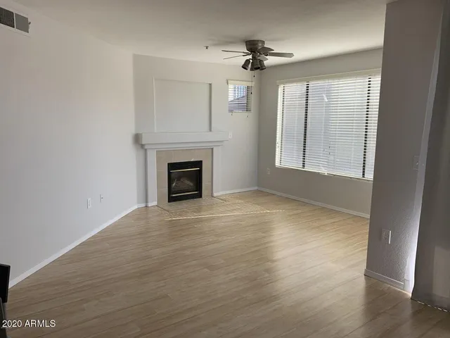 a view of empty room with wooden floor and fireplace