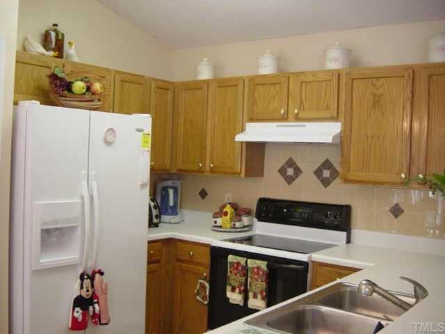 116 Saddle River Road Apex, NC 27502 - Photo 4 of 10 This lovely kitchen features tile flooring, backsplash, smoothtop elecric range, and oak cabinets. The bar area adds extra dining space needed for guests.