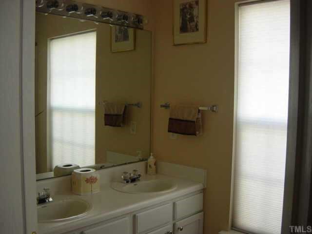 116 Saddle River Road Apex, NC 27502 - Photo 6 of 10 The master bath is complete with dual sinks, garden tub with ceramic shower wall, water closet, tile floors and white cabinets.