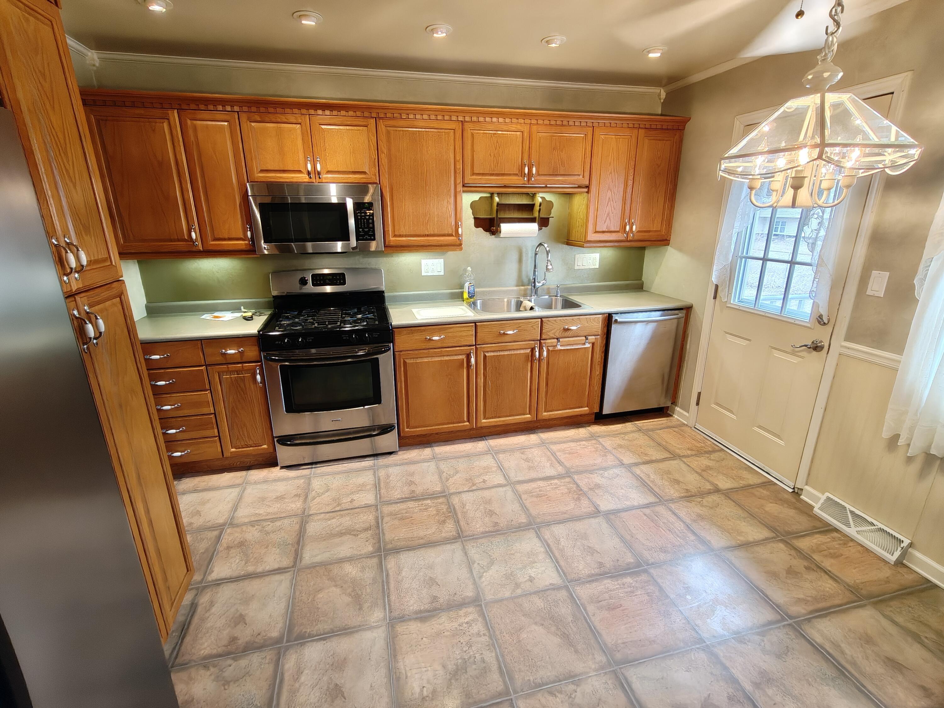 134 Elm Court Hebron, IN 46341 - Photo 6 of 36 a kitchen with stainless steel appliances granite countertop a stove a sink and a microwave
