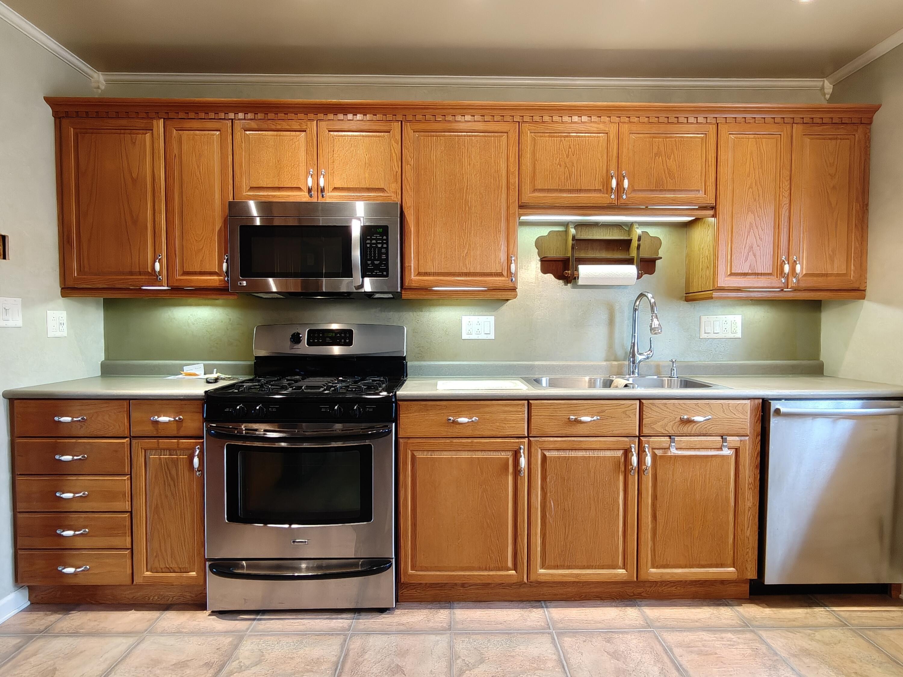 134 Elm Court Hebron, IN 46341 - Photo 9 of 36 a kitchen with stainless steel appliances granite countertop a stove a sink and a microwave
