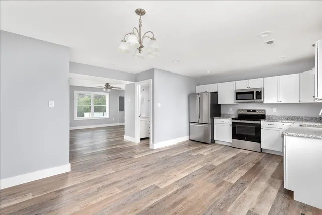 a kitchen with stainless steel appliances granite countertop a refrigerator and a stove top oven