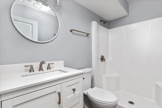 a bathroom with a sink a toilet and a mirror