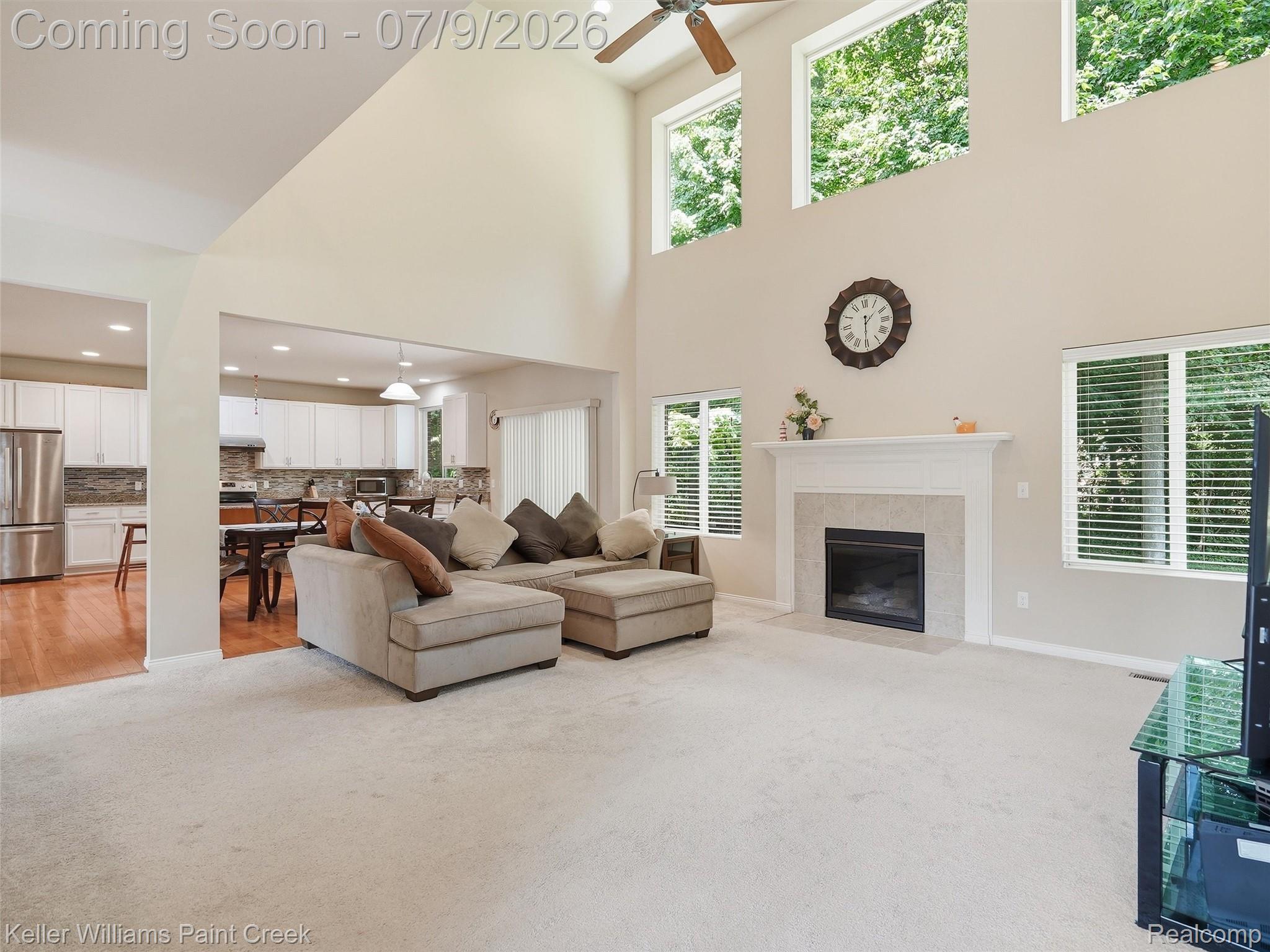 846 Monterey Ln. Rochester, MI 48307 - Photo 10 of 52 Spacious living area featuring a vaulted ceiling with a ceiling fan, a gas fireplace with a tiled surround and white mantel, and extensive natural light from multiple windows