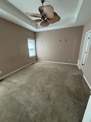 a view of an empty room and a ceiling fan