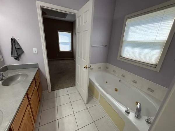 a bathroom with a tub sink and mirror