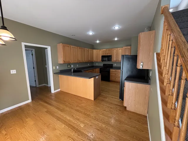 a kitchen with stainless steel appliances granite countertop a refrigerator a stove a sink and a microwave