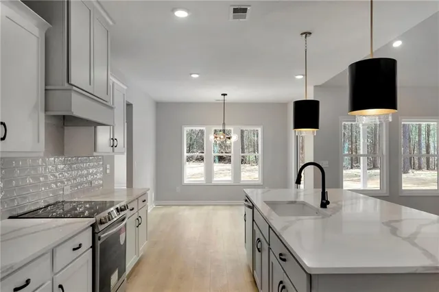 a kitchen with stainless steel appliances white cabinets and a refrigerator