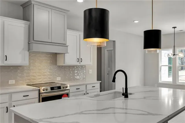 a kitchen with stainless steel appliances a sink a stove and a refrigerator