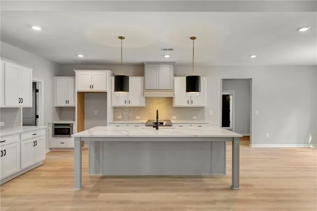 a view of an empty room with chandelier and window