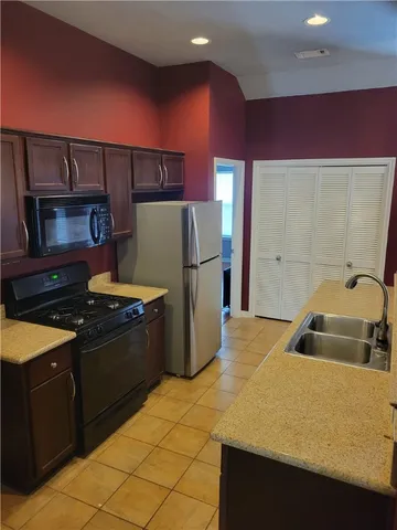 a kitchen with stainless steel appliances granite countertop a refrigerator and a stove