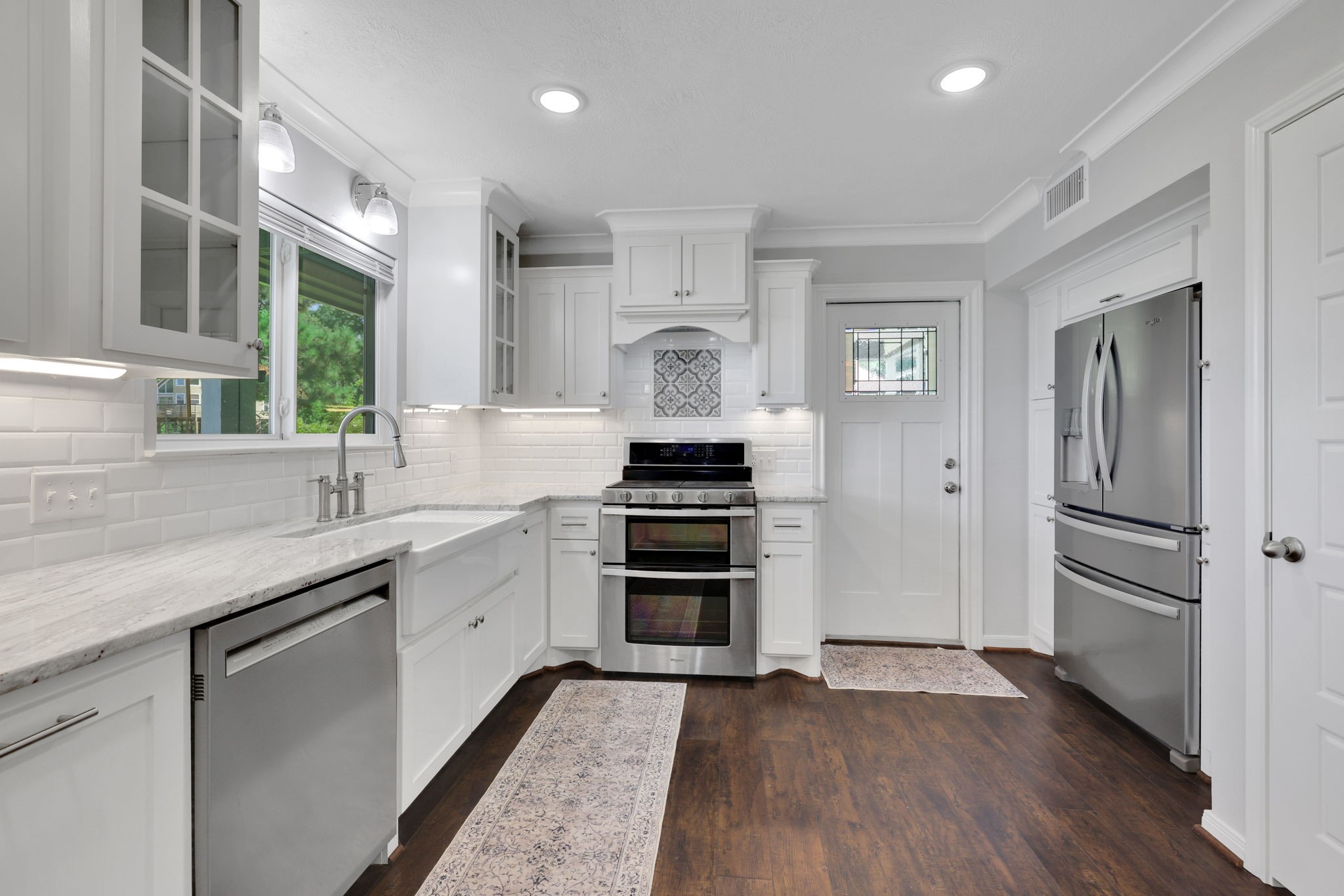 20 Ridgeway Drive Coldspring, TX 77331 - Photo 4 of 40 The white cabinets, subway tile, and stainless appliances pair well with the dark wood look flooring.