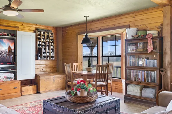 a living room with furniture a rug and a floor to ceiling window