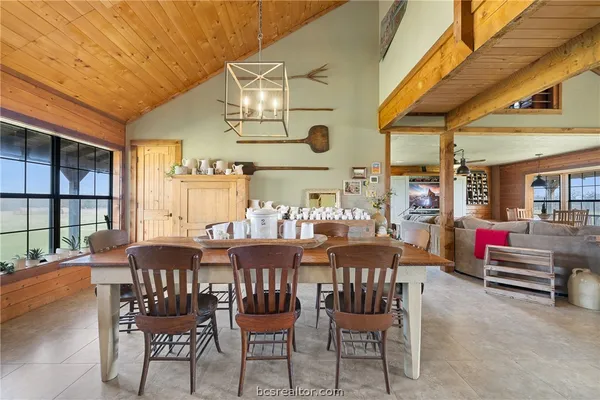 a kitchen with stainless steel appliances a table chairs and a refrigerator