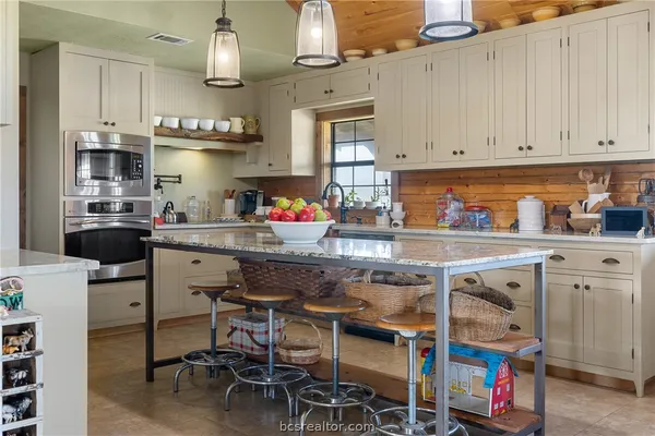 a kitchen with granite countertop white cabinets and white appliances