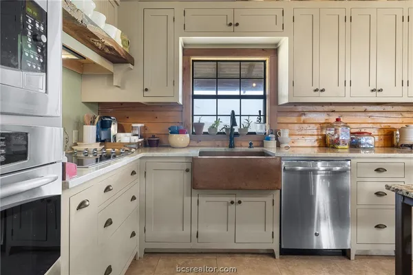 a kitchen with stainless steel appliances granite countertop a sink stove and cabinets