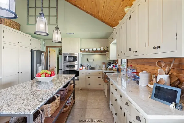 a kitchen with granite countertop a sink stove and cabinets