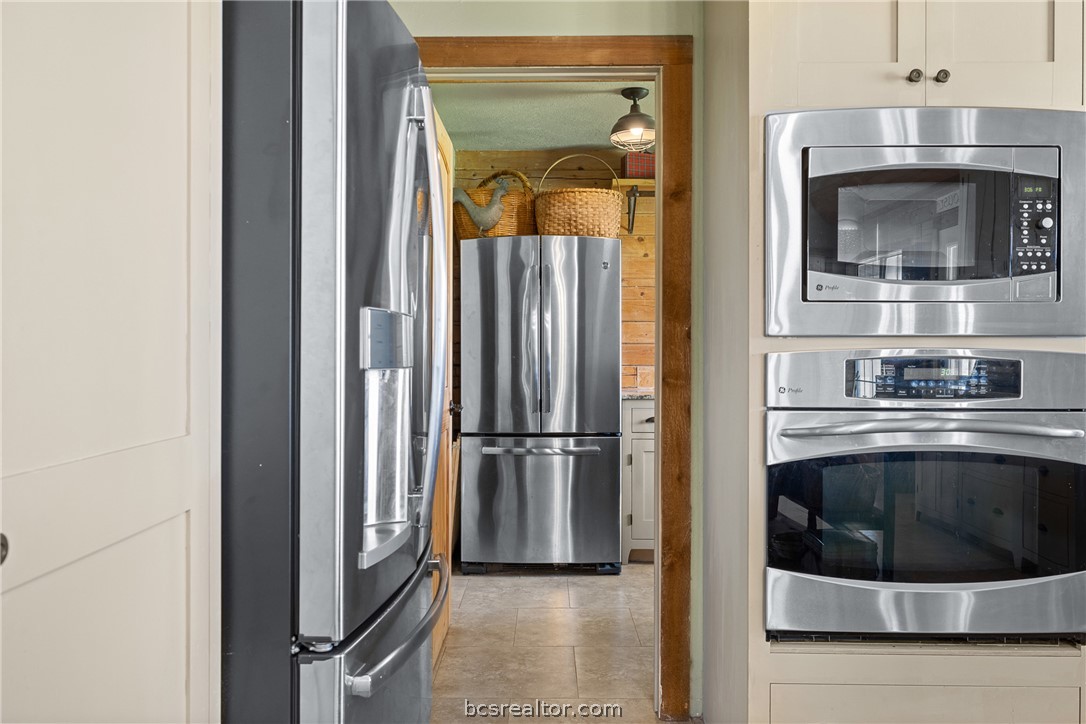 8501 Grassbur Road Bryan, TX 77808 - Photo 21 of 36 a kitchen with a refrigerator and cabinets