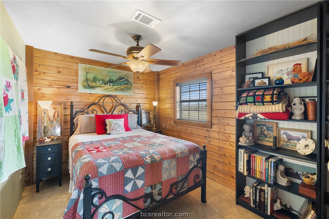 8501 Grassbur Road Bryan, TX 77808 - Photo 25 of 36 a bedroom with a bed a dresser and a book shelf