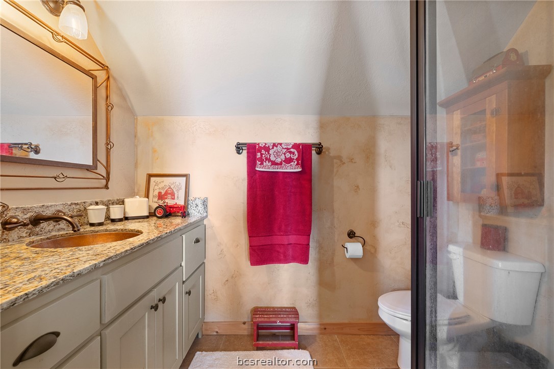 8501 Grassbur Road Bryan, TX 77808 - Photo 29 of 36 a bathroom with a granite countertop sink and a mirror