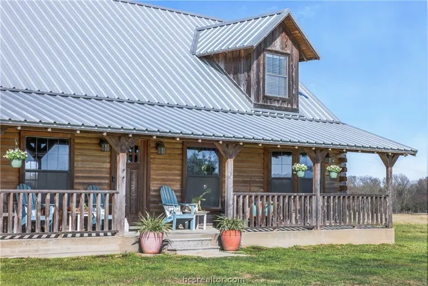 a view of a house with a deck and a yard