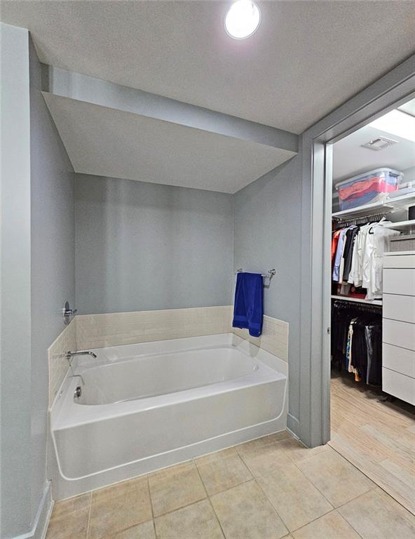 4561 Olde Perimeter Way, Unit 1002 Atlanta, GA 30346 - Photo 14 of 43 a bathroom with a bathtub and a shower