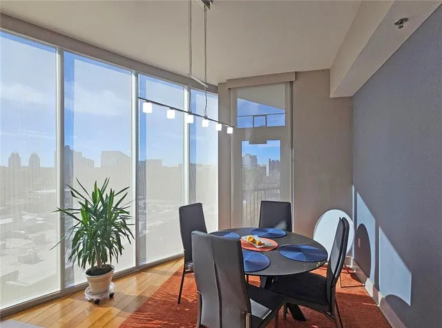 a dining room with furniture potted plants and wooden floor