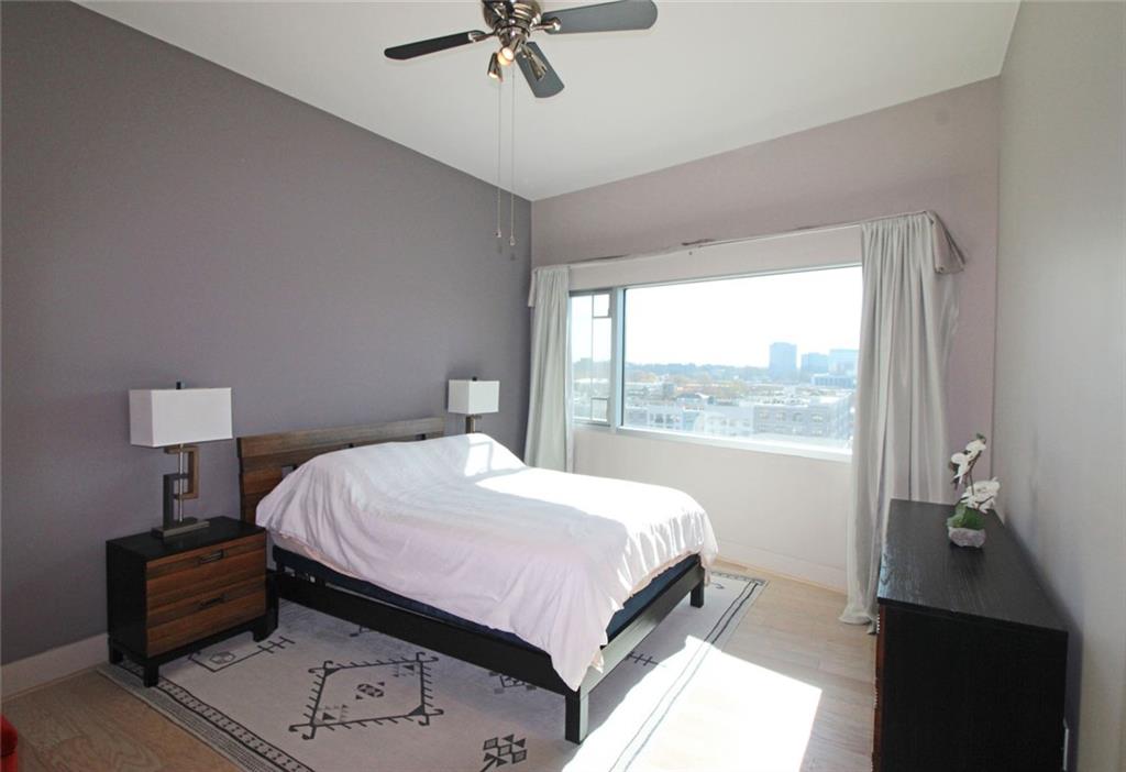 4561 Olde Perimeter Way, Unit 1002 Atlanta, GA 30346 - Photo 10 of 43 a bed sitting in a bedroom next to a window