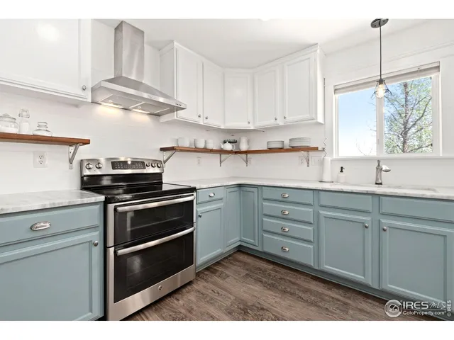 a kitchen with cabinets appliances a sink and a window