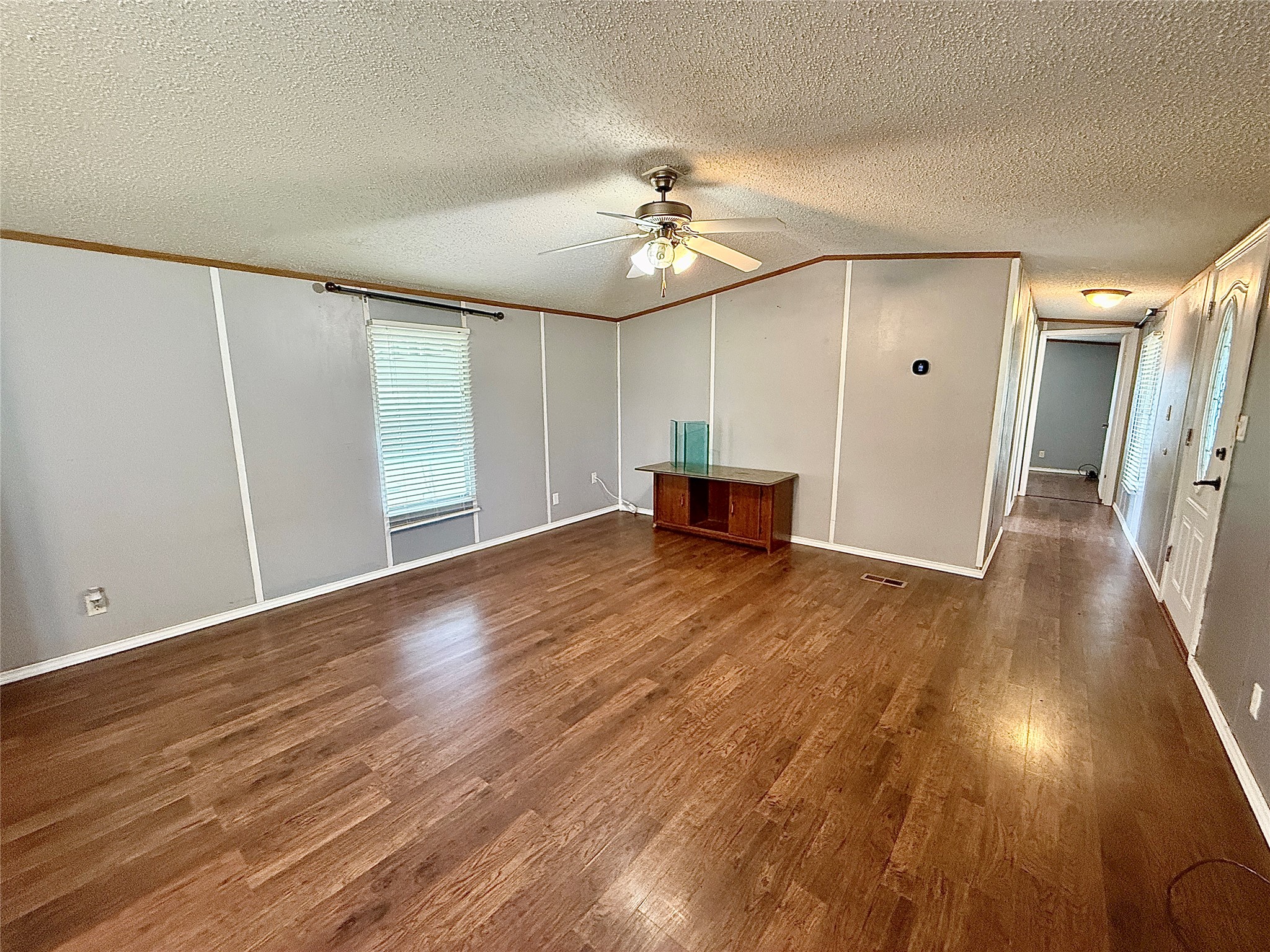 3075 FM 2001 Buda, TX 78610 - Photo 4 of 26 A well-lit living area features wood flooring.
