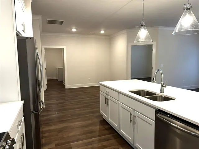 a kitchen with granite countertop a sink a stove and cabinets