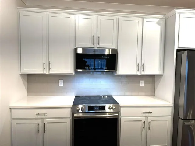 a kitchen with kitchen island a sink wooden floor and refrigerator