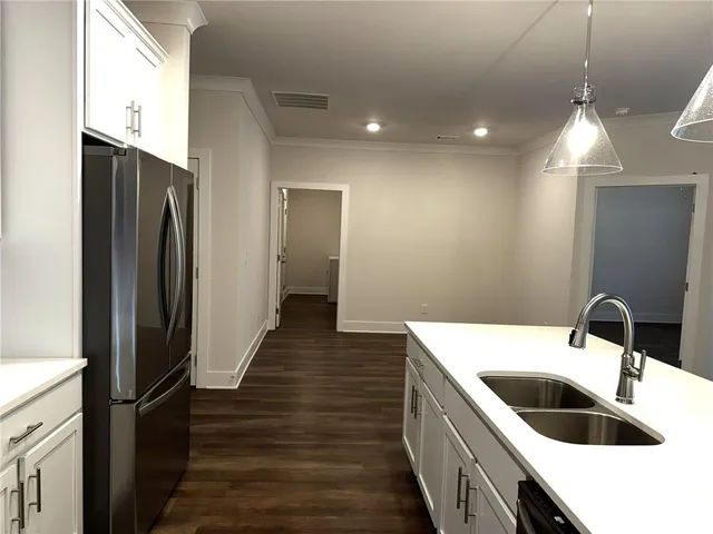 a view of kitchen with granite countertop stainless steel appliances and wooden floor