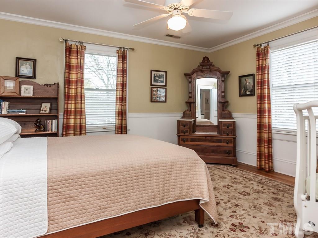 2025 St Marys Street Raleigh, NC 27608 - Photo 19 of 25 a bedroom with a large bed and a chandelier