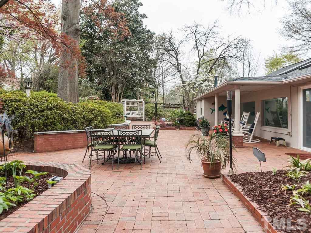 2025 St Marys Street Raleigh, NC 27608 - Photo 24 of 25 a view of a patio with table and chairs potted plants and large tree