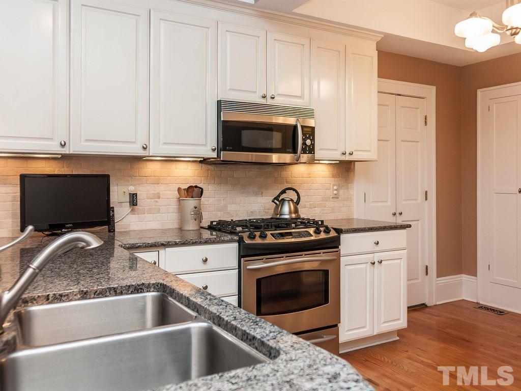 2025 St Marys Street Raleigh, NC 27608 - Photo 8 of 25 a kitchen with granite countertop white cabinets and stainless steel appliances