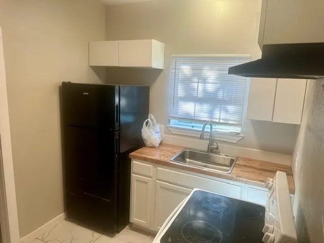 a kitchen with a sink a refrigerator and a stove