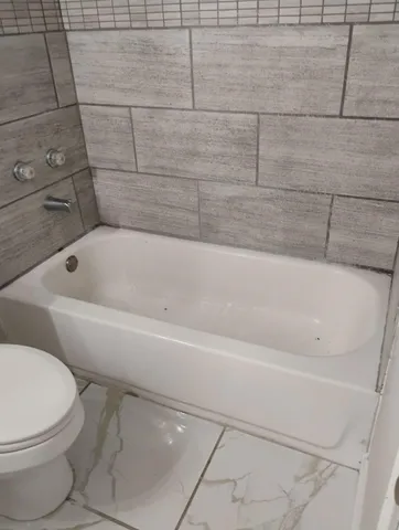 a bathroom with a toilet and bathtub