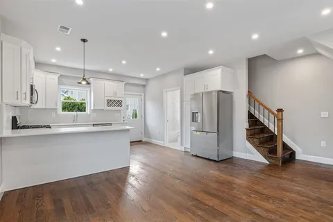 a kitchen with stainless steel appliances a refrigerator and wooden floor