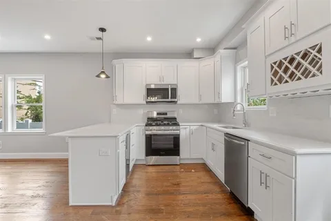 a kitchen with granite countertop a stove top oven sink and cabinets