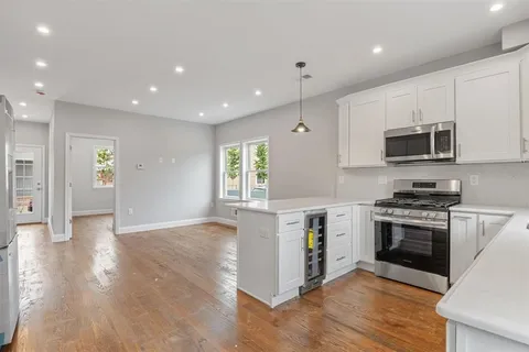a kitchen with granite countertop a stove top oven and a sink