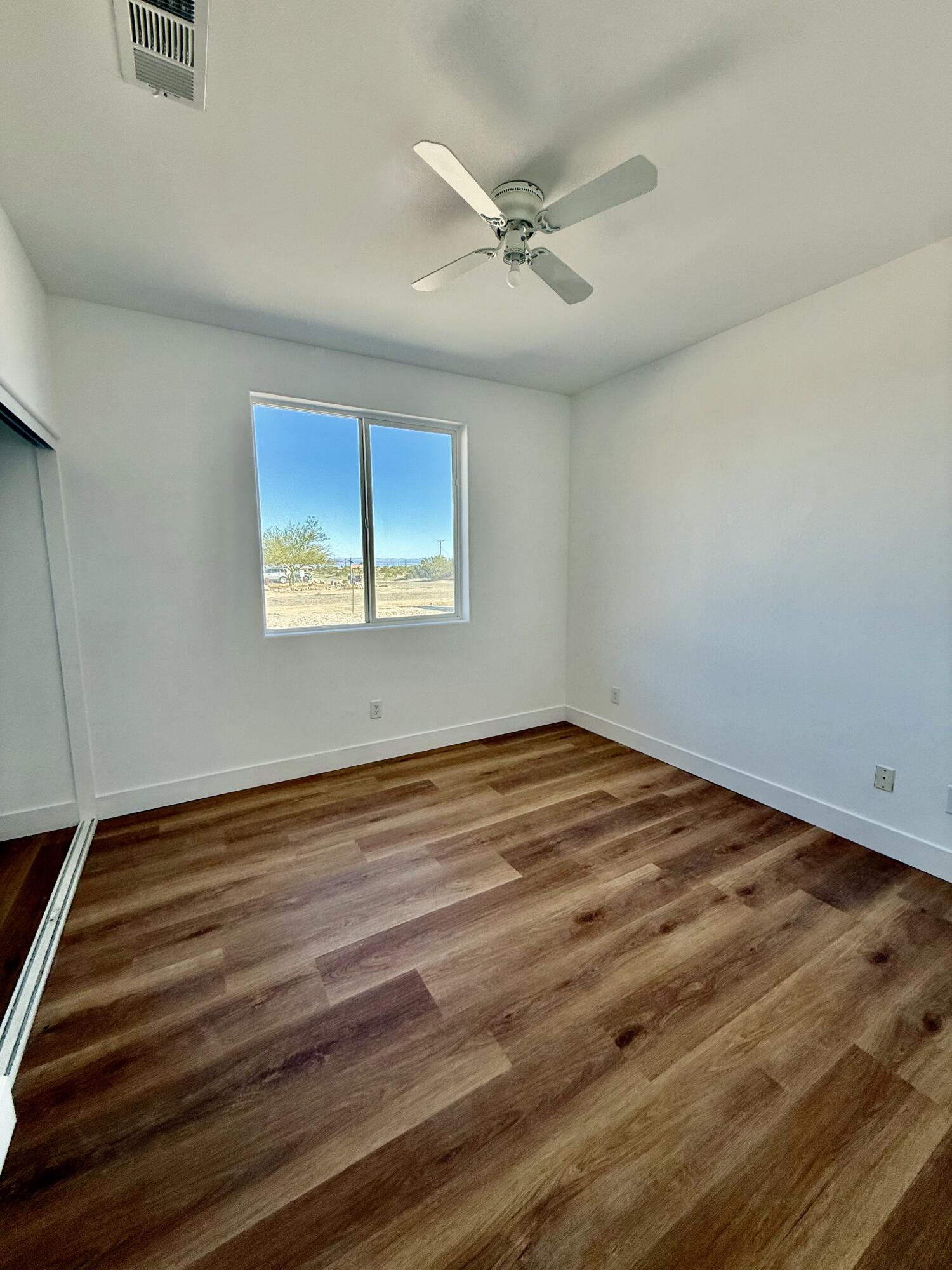 2283 Azure Avenue Thermal, CA 92274 - Photo 20 of 26 an empty room with wooden floor closet and windows