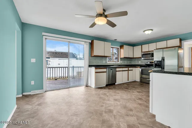 a kitchen with granite countertop a stove a sink a refrigerator and a microwave